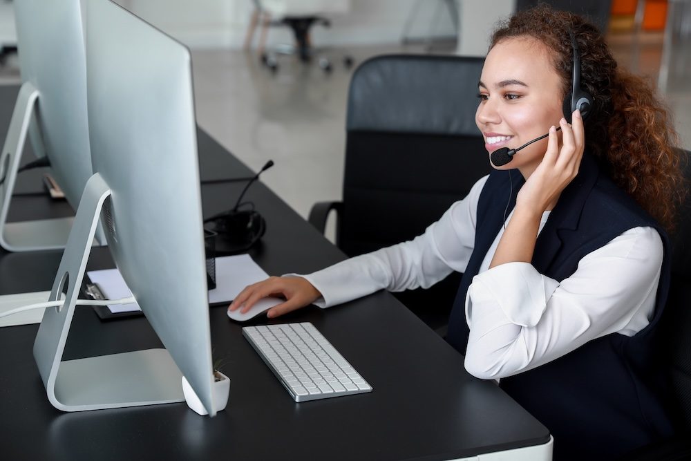Dispatcher wearing a headset while managing field service operations on a computer